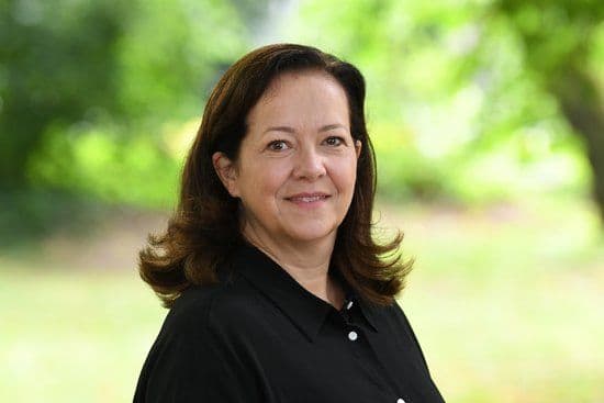 Anne-Christin Aufrecht vor einem grün bepflanzten Hintergrund