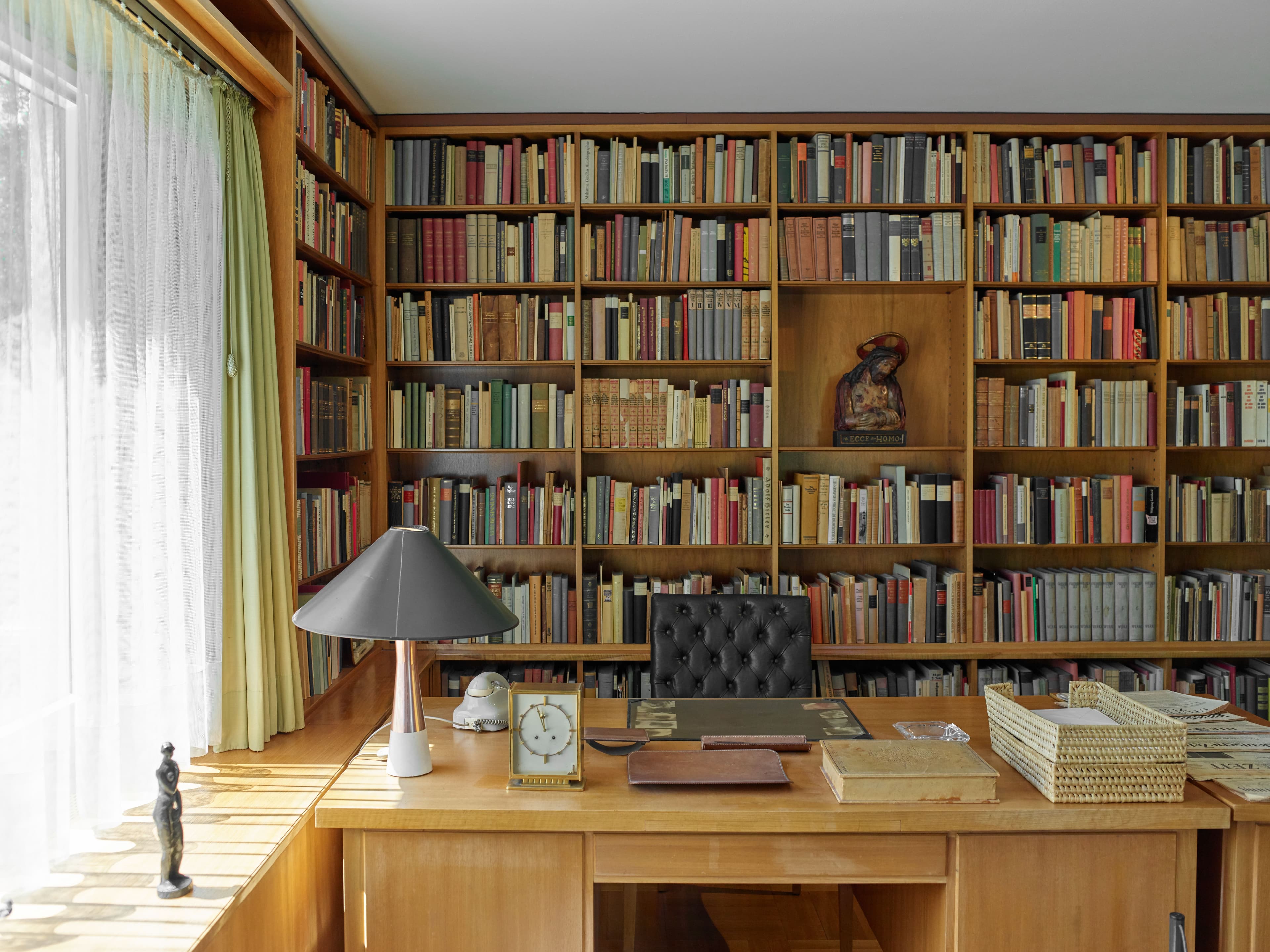Ein Büro mit vielen Büchern und Holzmöbeln.