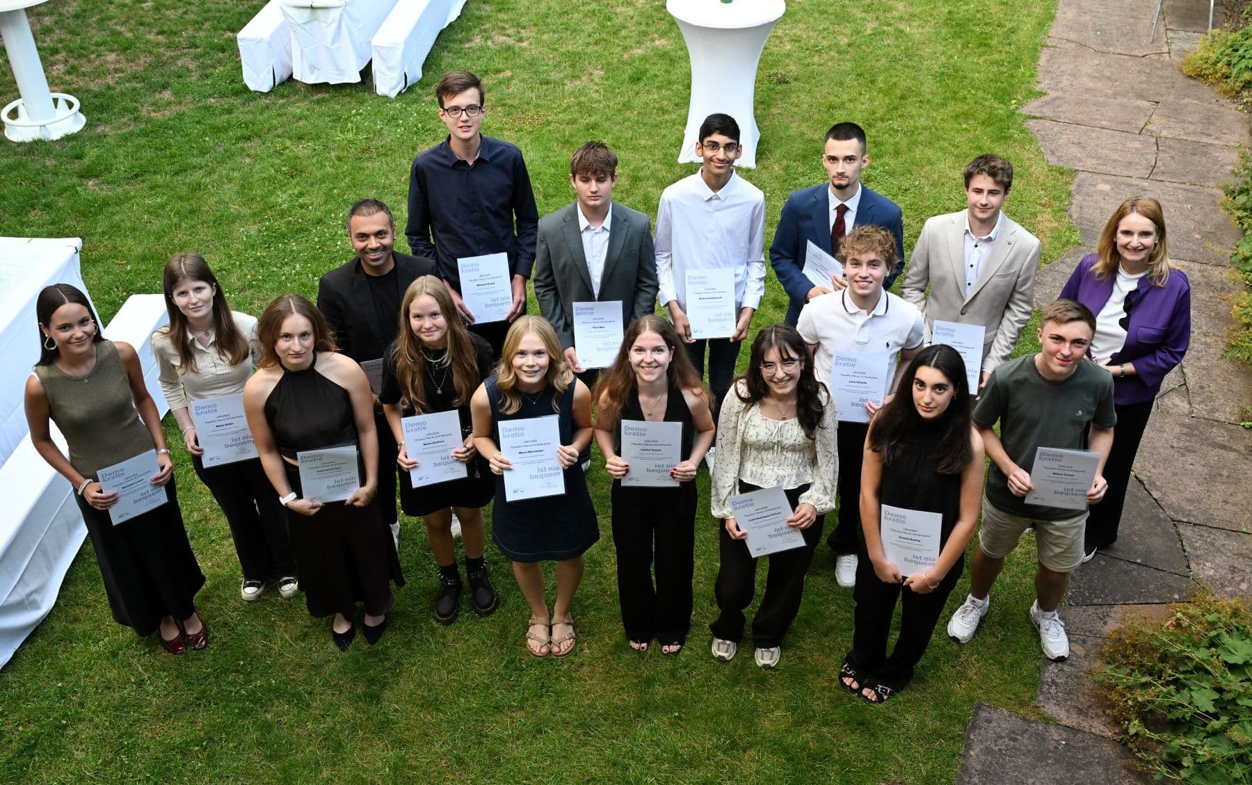 Gruppenfoto der Preisträger im Garten. In den Händen halten sie Urkunden.